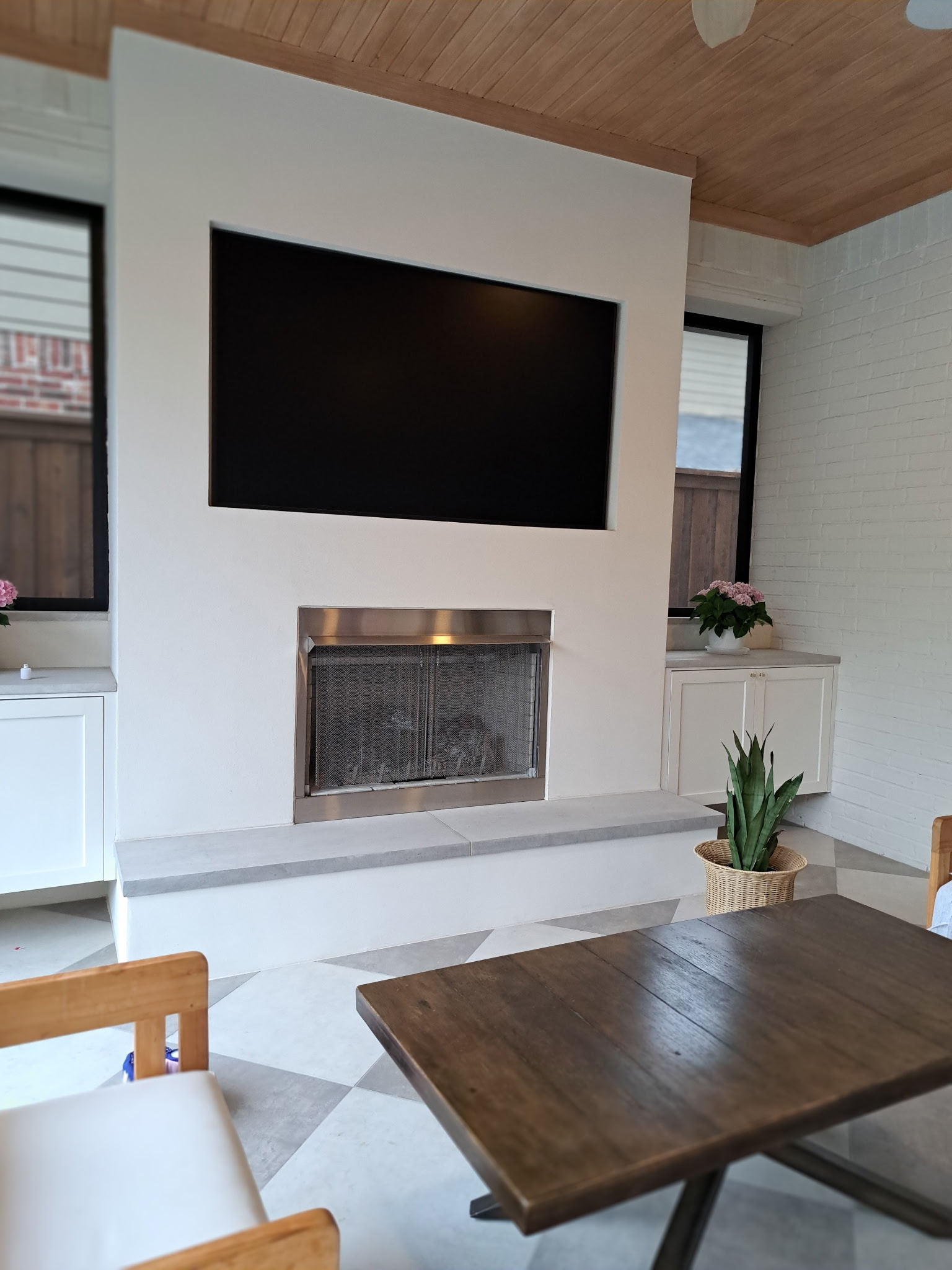 Covered patio with fireplace, television and custom finishes